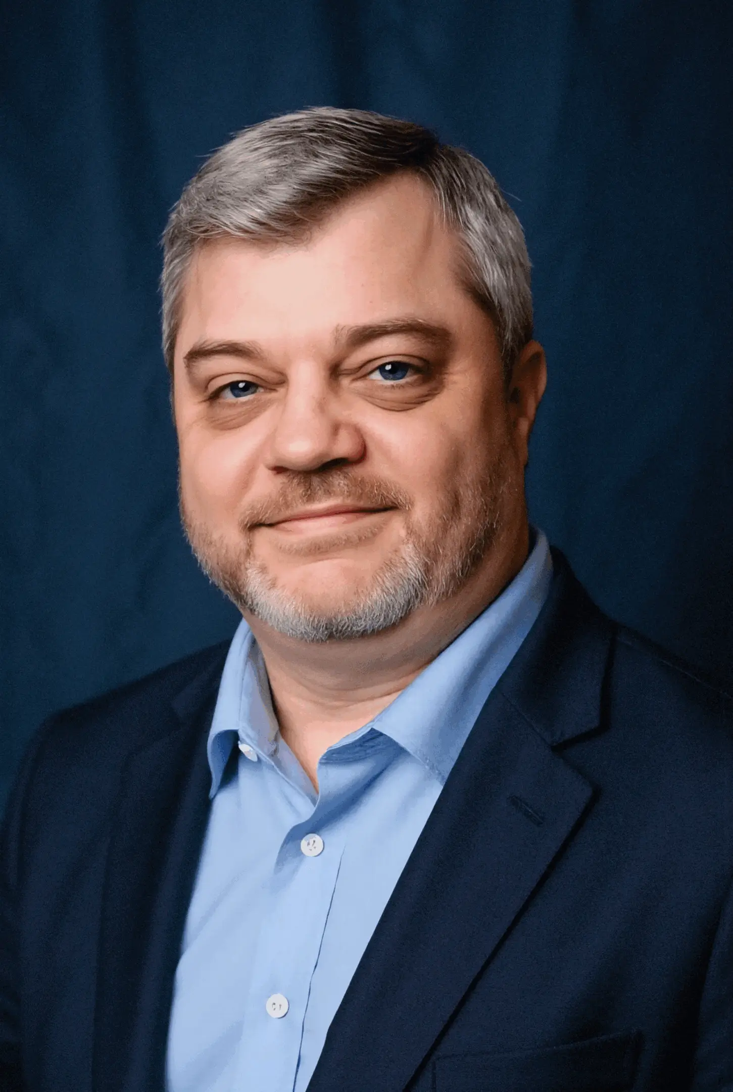 Man in a blue suit, smiling.