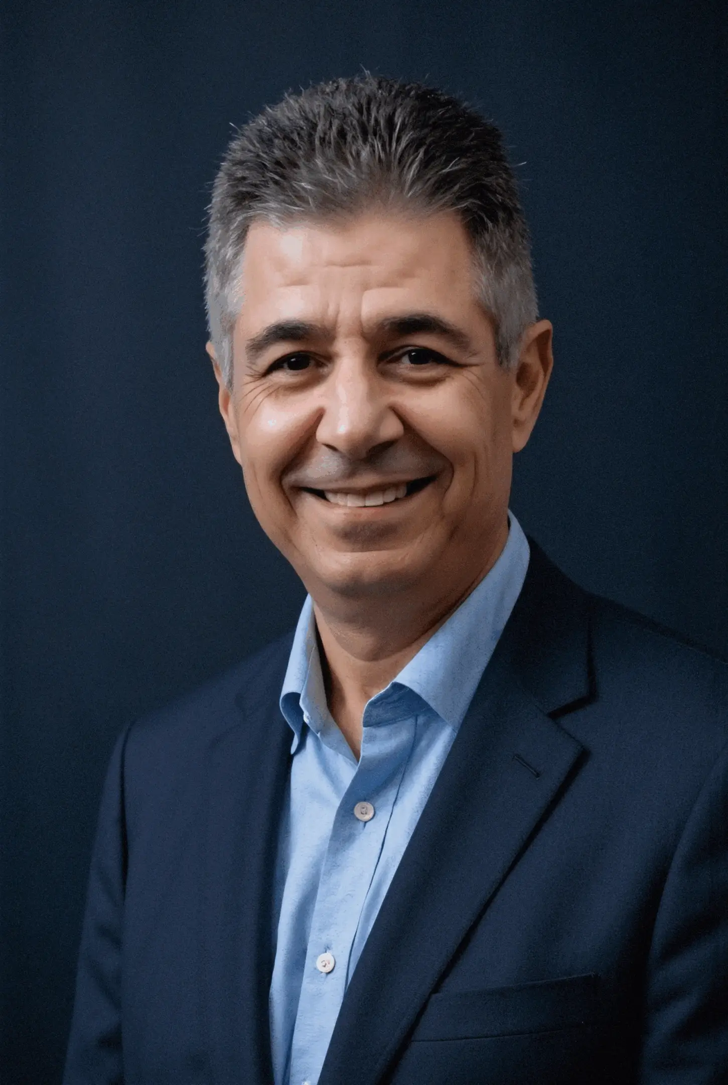 Smiling man in suit against dark background.